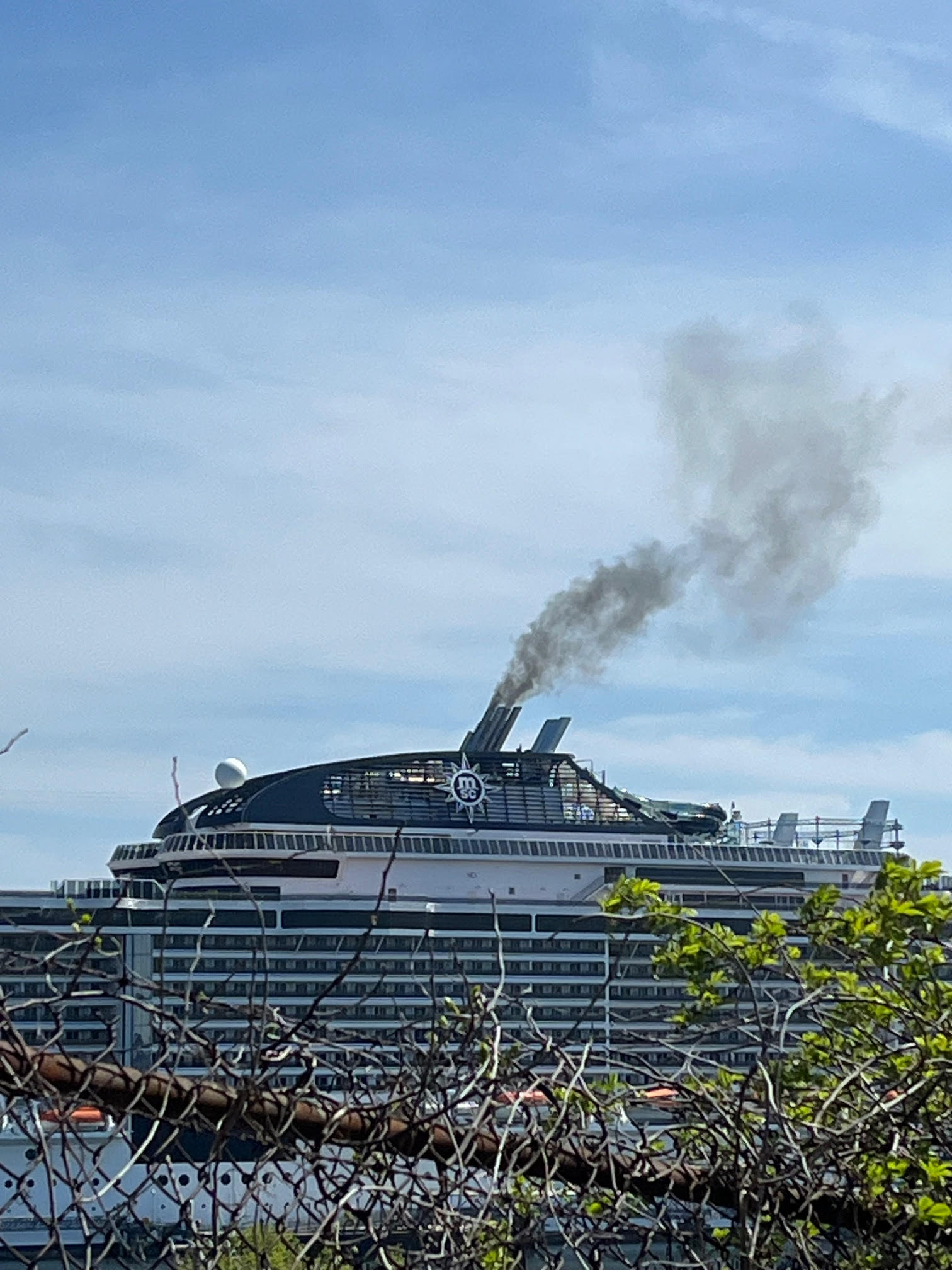 Cruise ship at night with visible pollution from scrubbers